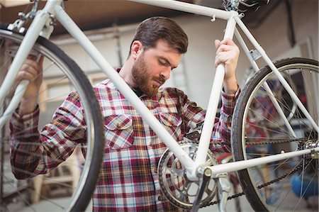 simsearch:6109-08782883,k - Mechanic repairing a bicycle in workshop Photographie de stock - Premium Libres de Droits, Code: 6109-08689857