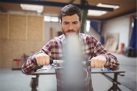 simsearch:6109-08782883,k - Mechanic repairing a bicycle in workshop Photographie de stock - Premium Libres de Droits, Code: 6109-08689855