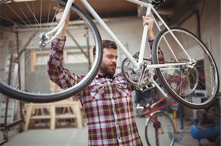 simsearch:6109-08782883,k - Mechanic repairing a bicycle in workshop Photographie de stock - Premium Libres de Droits, Code: 6109-08689856