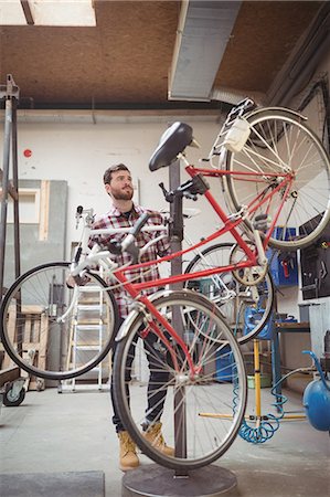 simsearch:6109-08782883,k - Mechanic repairing a bicycle in workshop Photographie de stock - Premium Libres de Droits, Code: 6109-08689858