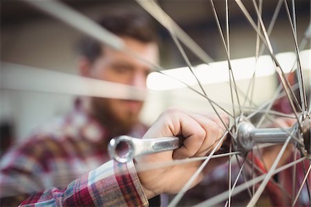 simsearch:6109-08782883,k - Mechanic repairing a bicycle in workshop Photographie de stock - Premium Libres de Droits, Code: 6109-08689862