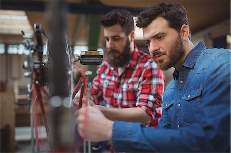 simsearch:6109-08690493,k - Side view of two mechanics repairing a bicycle in their workshop Stockbilder - Premium RF Lizenzfrei, Bildnummer: 6109-08689896