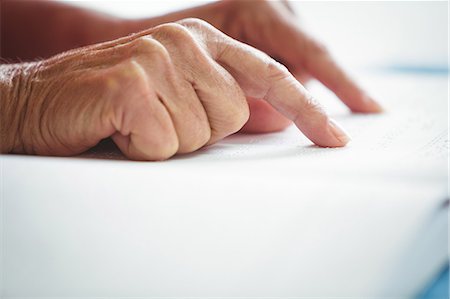 relaxed older lady reading book - Close-up of two pointing finger on a book Foto de stock - Sin royalties Premium, Código: 6109-08689816