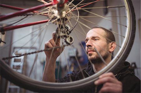 simsearch:6109-08782883,k - Mechanic repairing a bicycle in workshop Photographie de stock - Premium Libres de Droits, Code: 6109-08689838