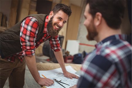 Carpenter working on a blueprint in workshop Foto de stock - Sin royalties Premium, Código: 6109-08689951