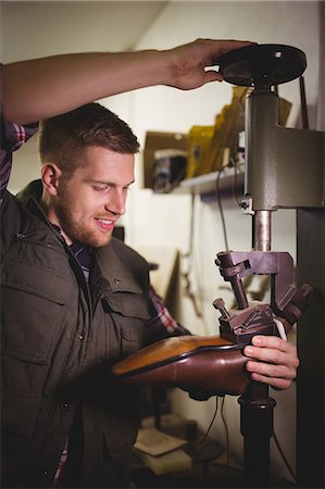 simsearch:700-06334769,k - Cobbler using a machine on a shoe sole in a workshop Stock Photo - Premium Royalty-Free, Code: 6109-08689996