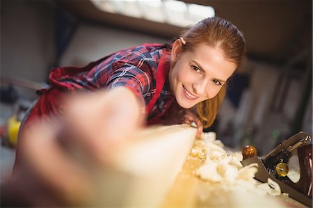 simsearch:6109-08538063,k - Female carpenter measuring length of wooden plank with measuring tape Foto de stock - Sin royalties Premium, Código: 6109-08689917