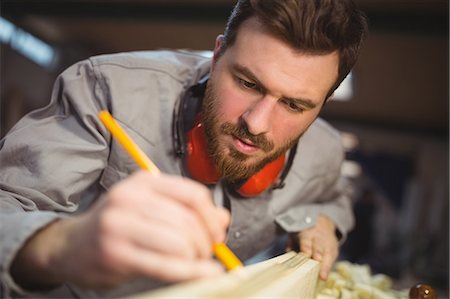 simsearch:6118-08660112,k - Carpenter marking on wooden plank with pencil in workshop Foto de stock - Royalty Free Premium, Número: 6109-08689921