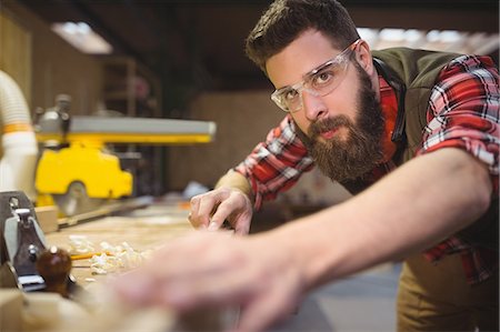 simsearch:6118-08660112,k - Portrait of carpenter measuring wooden plank in workshop Foto de stock - Royalty Free Premium, Número: 6109-08689925