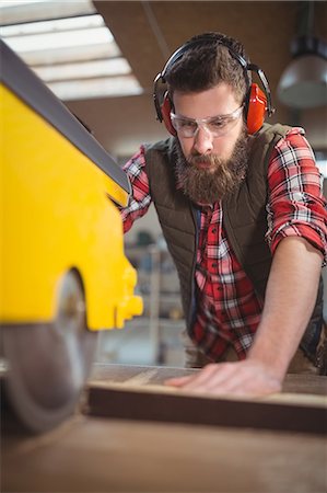 simsearch:6109-08700955,k - Carpenter using saw cutting machine in workshop Fotografie stock - Premium Royalty-Free, Codice: 6109-08689929