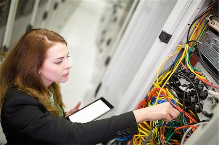 repairing woman - Technician holding digital tablet while examining server in server room Stock Photo - Premium Royalty-Free, Code: 6109-08690090