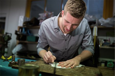 simsearch:6109-08690033,k - Cobbler cutting a piece of material in workshop Foto de stock - Sin royalties Premium, Código: 6109-08690016