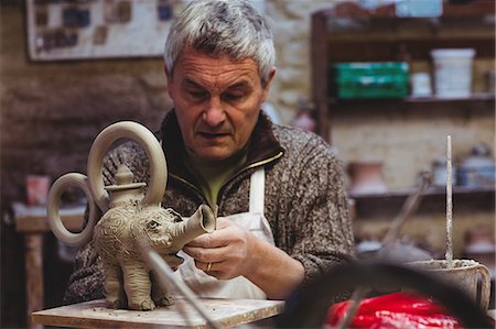 Mature artist preparing clay elephant in workshop Stock Photo - Premium Royalty-Free, Code: 6109-08690174