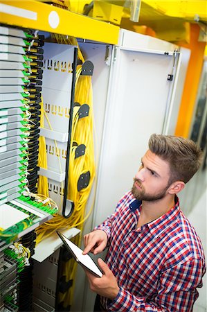 simsearch:632-07809292,k - Technician using digital tablet while analyzing server in server room Stock Photo - Premium Royalty-Free, Code: 6109-08690111