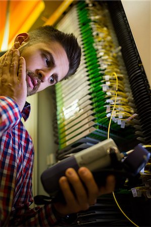 simsearch:6109-08690053,k - Technician using digital cable analyzer in server room Stock Photo - Premium Royalty-Free, Code: 6109-08690117