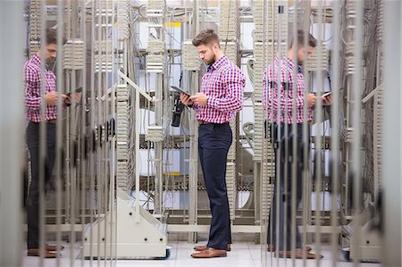 simsearch:632-07809292,k - Technician using digital tablet while analyzing server in server room Stock Photo - Premium Royalty-Free, Code: 6109-08690131