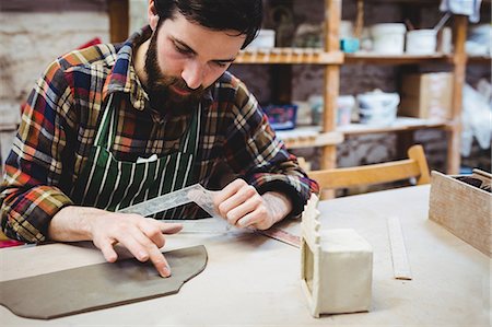 simsearch:6109-08705486,k - Focused man working at table in workshop Photographie de stock - Premium Libres de Droits, Code: 6109-08690203