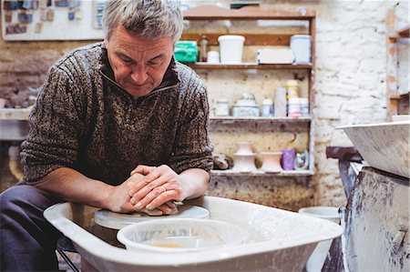 Focused mature man molding clay at workshop Foto de stock - Sin royalties Premium, Código: 6109-08690213