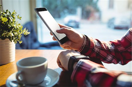 Close-up of customer using mobile phone at cafe Foto de stock - Sin royalties Premium, Código: 6109-08690374