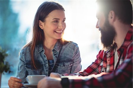 simsearch:6109-08690396,k - Happy young couple talking at cafe Stock Photo - Premium Royalty-Free, Code: 6109-08690376