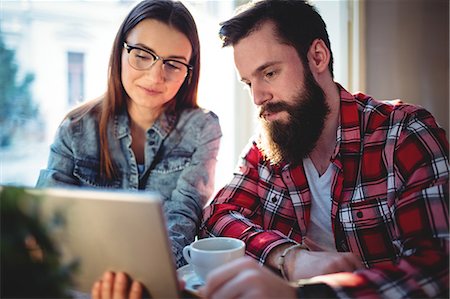 people at coffee shop with computers - Young couple using tablet at cafe Stock Photo - Premium Royalty-Free, Code: 6109-08690378