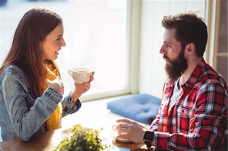 simsearch:6109-08690396,k - Happy woman talking to man while having coffee at cafe Stock Photo - Premium Royalty-Free, Code: 6109-08690391