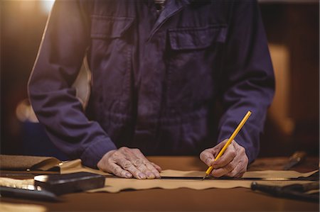 simsearch:649-06433434,k - Shoemaker cutting a piece of leather in workshop Photographie de stock - Premium Libres de Droits, Code: 6109-08763875