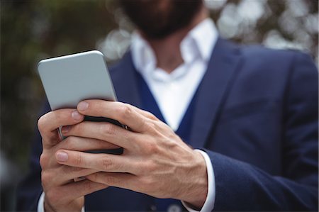 simsearch:6109-08830034,k - Close-up of businessman using mobile phone Fotografie stock - Premium Royalty-Free, Codice: 6109-08763969