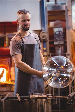 simsearch:6109-08830327,k - Glassblower shaping a molten glass at glassblowing factory Foto de stock - Royalty Free Premium, Número: 6109-08764078