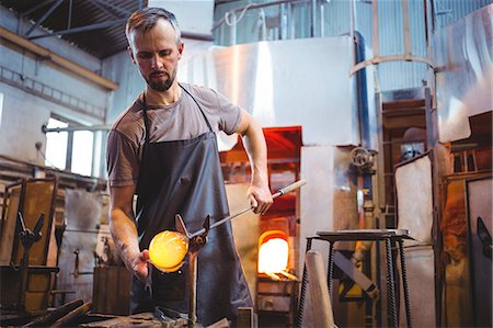 simsearch:6109-08830327,k - Glassblower forming and shaping a molten glass at glassblowing factory Foto de stock - Royalty Free Premium, Número: 6109-08764081