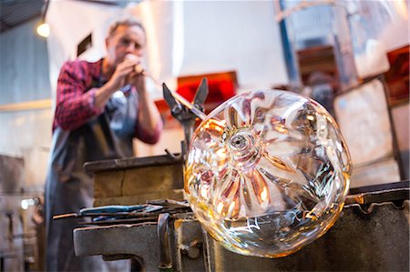 Glassblower shaping a glass on the blowpipe at glassblowing factory Stock Photo - Premium Royalty-Free, Code: 6109-08764082