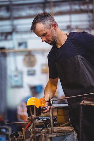 simsearch:614-06973581,k - Glassblower forming and shaping a molten glass at glassblowing factory Stock Photo - Premium Royalty-Free, Code: 6109-08764093
