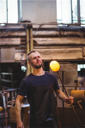 simsearch:6109-08830327,k - Glassblower shaping a molten glass at glassblowing factory Foto de stock - Royalty Free Premium, Número: 6109-08764091