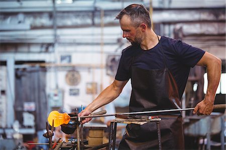 simsearch:614-06973581,k - Glassblower forming and shaping a molten glass at glassblowing factory Stock Photo - Premium Royalty-Free, Code: 6109-08764092