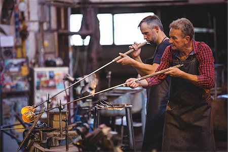 formando - Glassblower shaping a glass on the blowpipe at glassblowing factory Foto de stock - Sin royalties Premium, Código: 6109-08764099