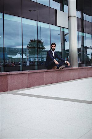 simsearch:622-08657638,k - Businessman practicing yoga outside office building Stock Photo - Premium Royalty-Free, Code: 6109-08764000