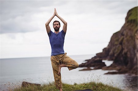 simsearch:622-01080568,k - Man performing yoga on cliff Foto de stock - Royalty Free Premium, Número: 6109-08764026