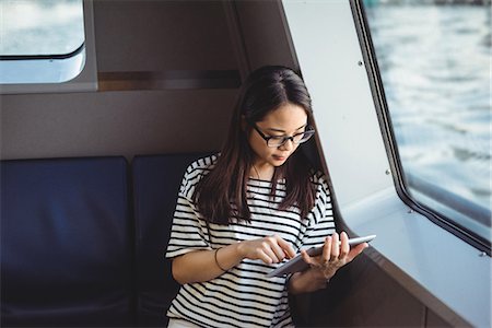 read - Young woman using digital tablet while travelling in ship Photographie de stock - Premium Libres de Droits, Code: 6109-08764178