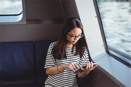 desplazar texto - Young woman using digital tablet while travelling in ship Foto de stock - Sin royalties Premium, Código: 6109-08764178