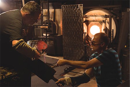 simsearch:614-06973581,k - Team of glassblower shaping a molten glass at glassblowing factory Stock Photo - Premium Royalty-Free, Code: 6109-08764199