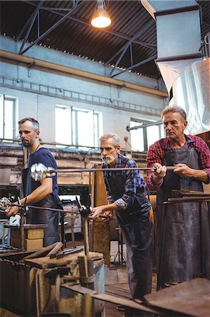 simsearch:6115-06967228,k - Team of glassblower shaping a glass on the blowpipe at glassblowing factory Photographie de stock - Premium Libres de Droits, Code: 6109-08764104