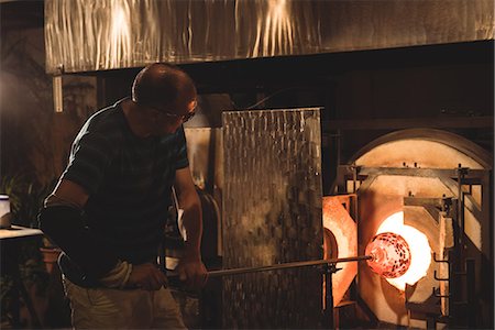 simsearch:400-05882411,k - Glassblower heating glass in furnace at glassblowing factory Foto de stock - Sin royalties Premium, Código: 6109-08764204