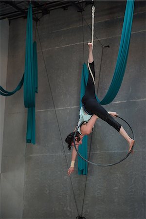 simsearch:858-05799276,k - Gymnast performing gymnastics on hoop in fitness studio Foto de stock - Sin royalties Premium, Código: 6109-08764217