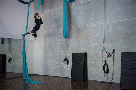 simsearch:400-04777468,k - Gymnast exercising on blue fabric rope in fitness studio Photographie de stock - Premium Libres de Droits, Code: 6109-08764226
