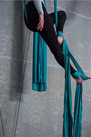 simsearch:6102-08951585,k - Gymnast exercising on blue fabric rope in fitness studio Stock Photo - Premium Royalty-Free, Code: 6109-08764234