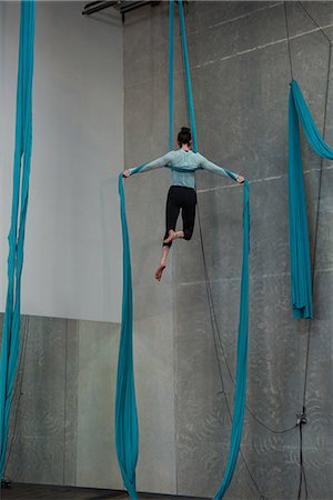 simsearch:400-04777468,k - Gymnast exercising on blue fabric rope in fitness studio Photographie de stock - Premium Libres de Droits, Code: 6109-08764236