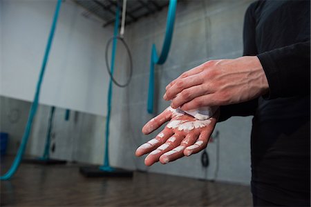 Gymnast rubbing chalk powder on her hands in fitness studio Stock Photo - Premium Royalty-Free, Code: 6109-08764238