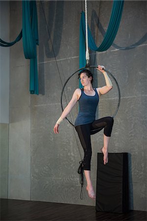 simsearch:6109-08739282,k - Gymnast performing gymnastics on hoop in fitness studio Photographie de stock - Premium Libres de Droits, Code: 6109-08764239