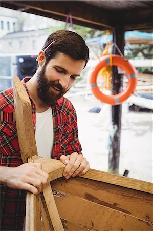 simsearch:6109-08764384,k - Man preparing wooden boat frame in boatyard Foto de stock - Sin royalties Premium, Código: 6109-08764348