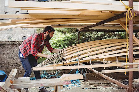 simsearch:6109-08764384,k - Man preparing wooden boat frame in boatyard Foto de stock - Sin royalties Premium, Código: 6109-08764351